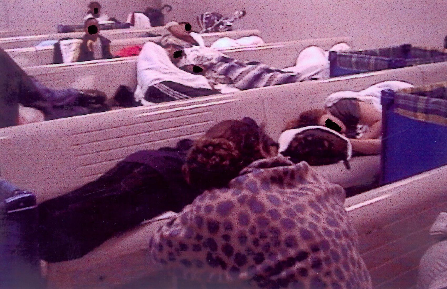 Homeless families with children sleeping on benches and the floor in Waiting Room A