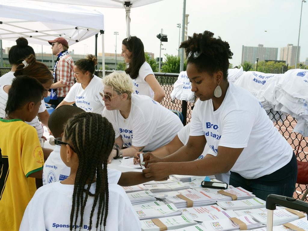 LAS staff hand out badges and assist community members at a field day sign up table